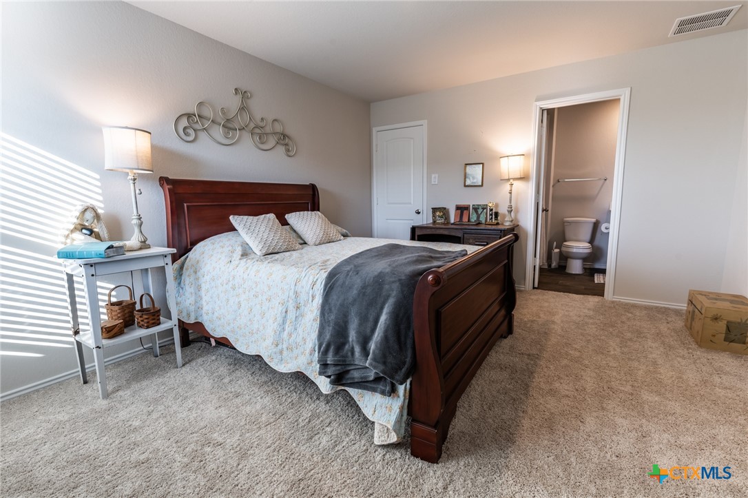 929 Indigo Way Seguin, TX 78155 - Photo 18 of 30 a spacious bedroom with a bed and a table in it