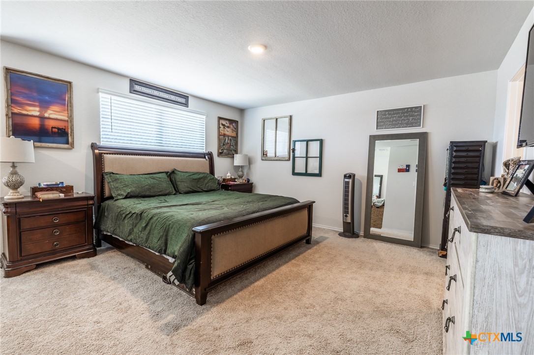 929 Indigo Way Seguin, TX 78155 - Photo 20 of 37 a spacious bedroom with a bed and a couch
