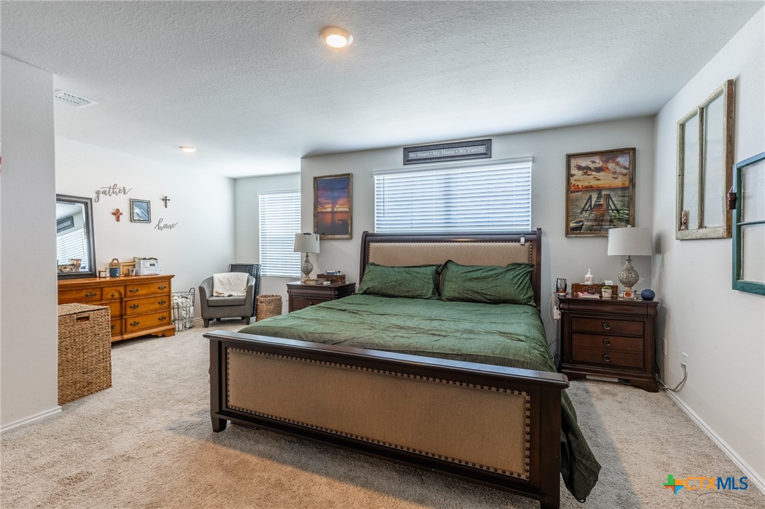 929 Indigo Way Seguin, TX 78155 - Photo 21 of 37 a bedroom with a bed and wooden floor