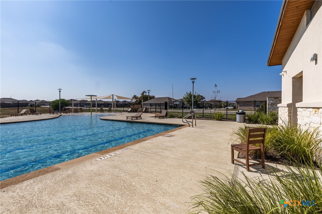 929 Indigo Way Seguin, TX 78155 - Photo 25 of 30 a view of a swimming pool with a chair and tables in the patio
