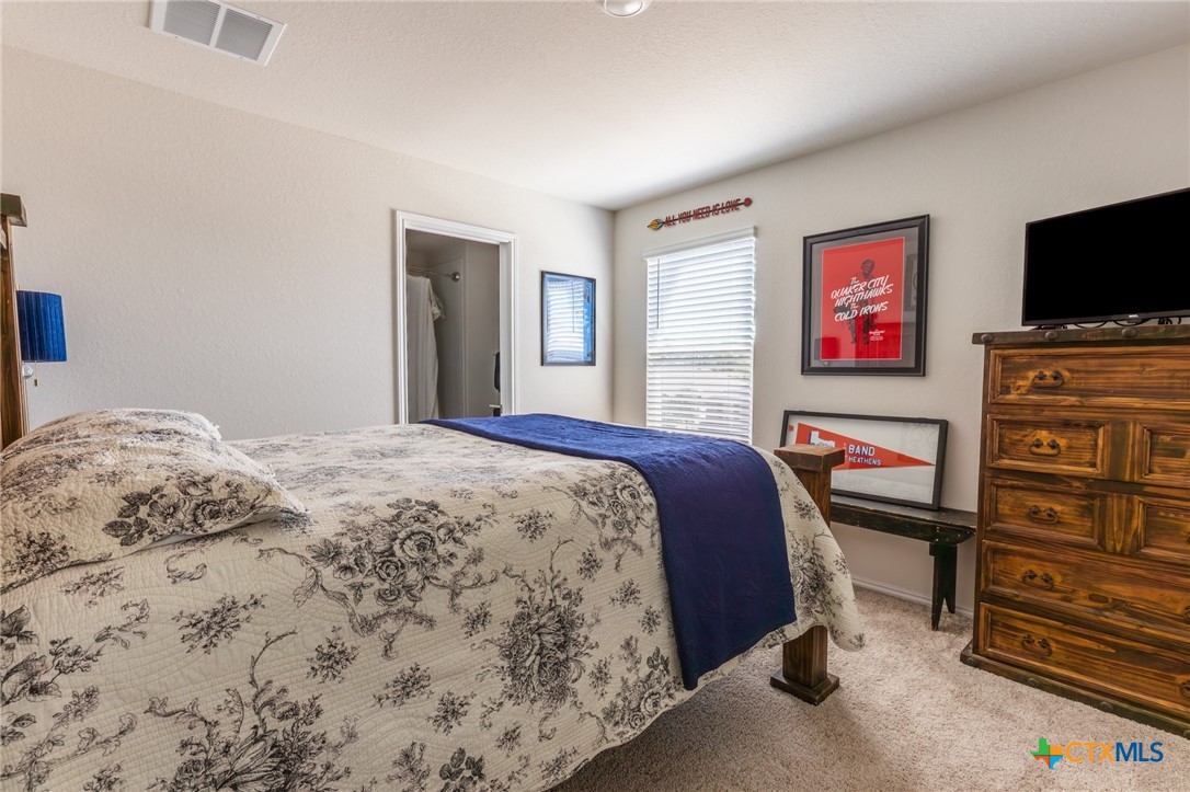 929 Indigo Way Seguin, TX 78155 - Photo 25 of 37 a bedroom with a bed and a flat screen tv