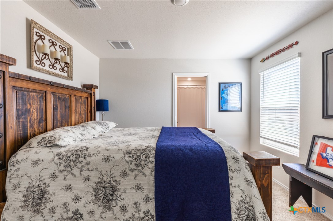 929 Indigo Way Seguin, TX 78155 - Photo 26 of 37 a bedroom with a bed and a dresser next to a window