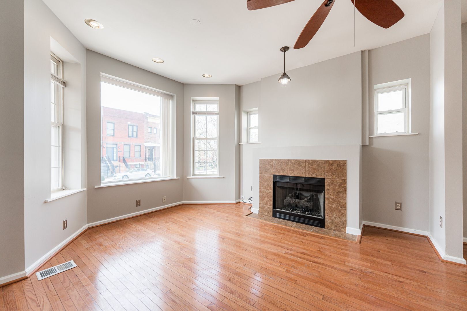 2916 West Warren Boulevard, Unit 1 Chicago, IL 60612 - Photo 2 of 16 an empty room with wooden floor fireplace and windows