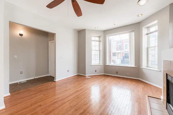 an empty room with wooden floor and windows