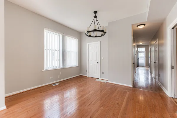 a view of empty room with wooden floor and window