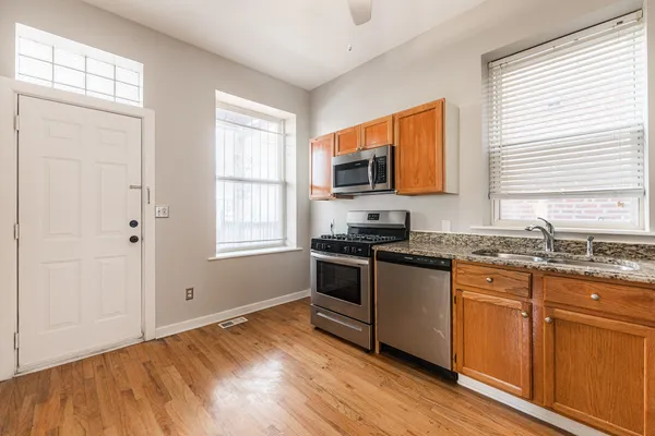 a kitchen with stainless steel appliances granite countertop a stove a sink and a microwave