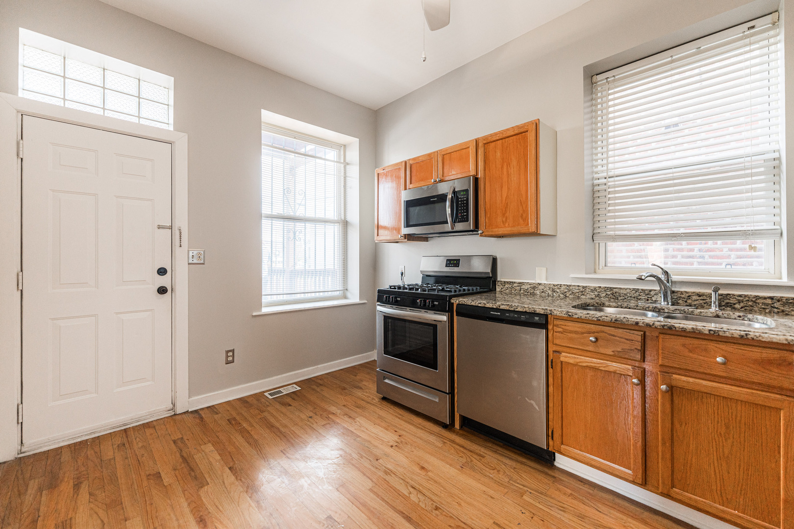 2916 West Warren Boulevard, Unit 1 Chicago, IL 60612 - Photo 6 of 16 a kitchen with stainless steel appliances granite countertop a stove a sink and a microwave