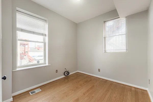 a view of a room with wooden floor and windows