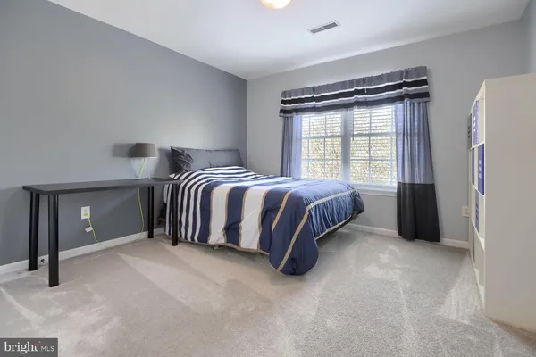 a spacious bedroom with a bed and a window