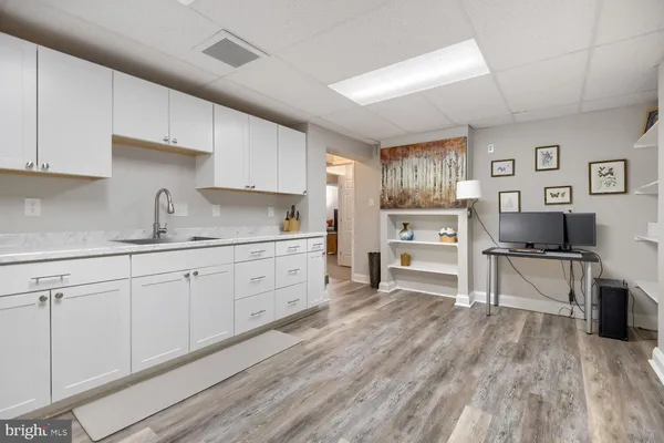 a kitchen with cabinets stainless steel appliances a sink and wooden floor