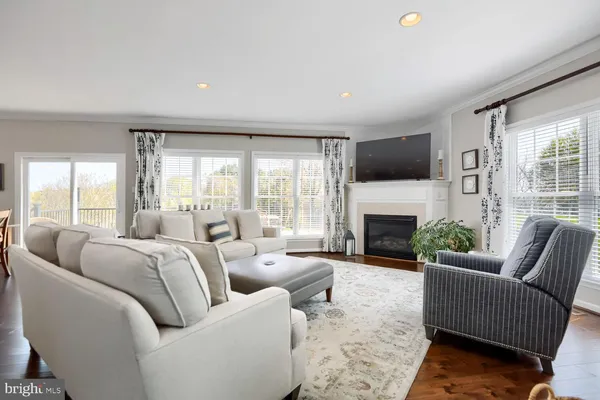 a living room with furniture a large window and a fireplace