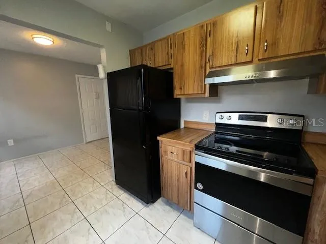 a kitchen with stainless steel appliances wooden cabinets sink and stove