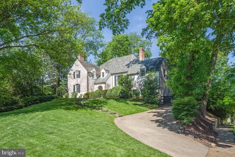 a front view of a house with a yard and green space