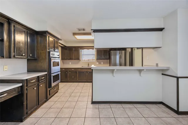a kitchen with stainless steel appliances a sink and a refrigerator
