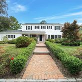 a front view of a house with yard and green space