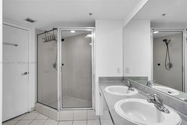 a bathroom with a shower sink vanity and mirror
