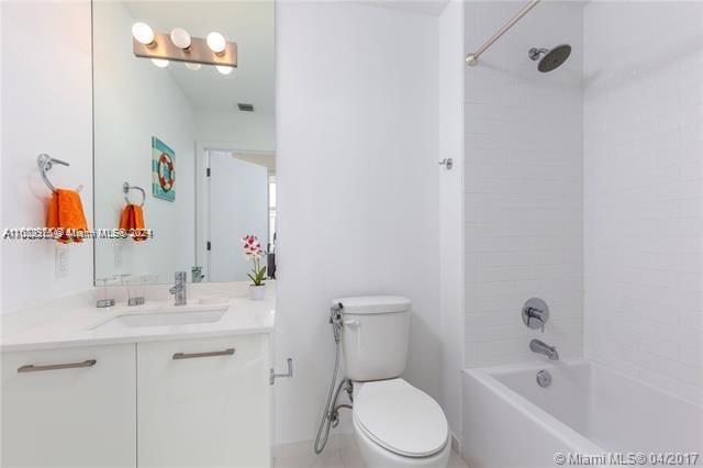 151 Southeast 1st Street, Unit 2811 Miami, FL 33131 - Photo 11 of 18 a bathroom with a bathtub shower sink vanity mirror and toilet