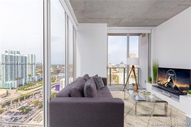 151 Southeast 1st Street, Unit 2811 Miami, FL 33131 - Photo 4 of 18 a living room with furniture and a floor to ceiling window