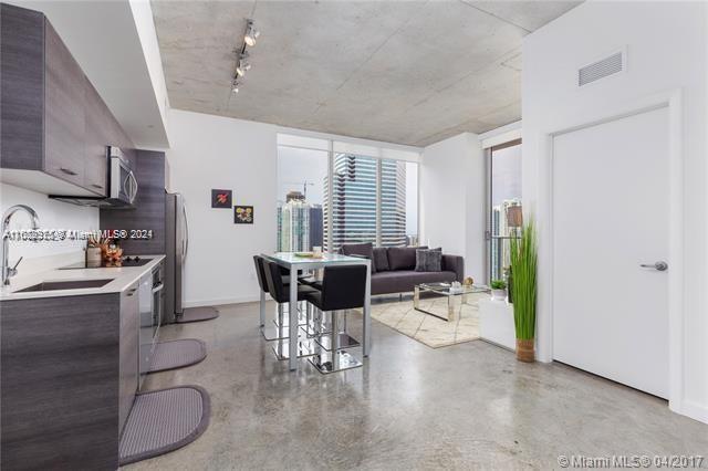 151 Southeast 1st Street, Unit 2811 Miami, FL 33131 - Photo 5 of 18 a living room with furniture a dining table and a potted plant