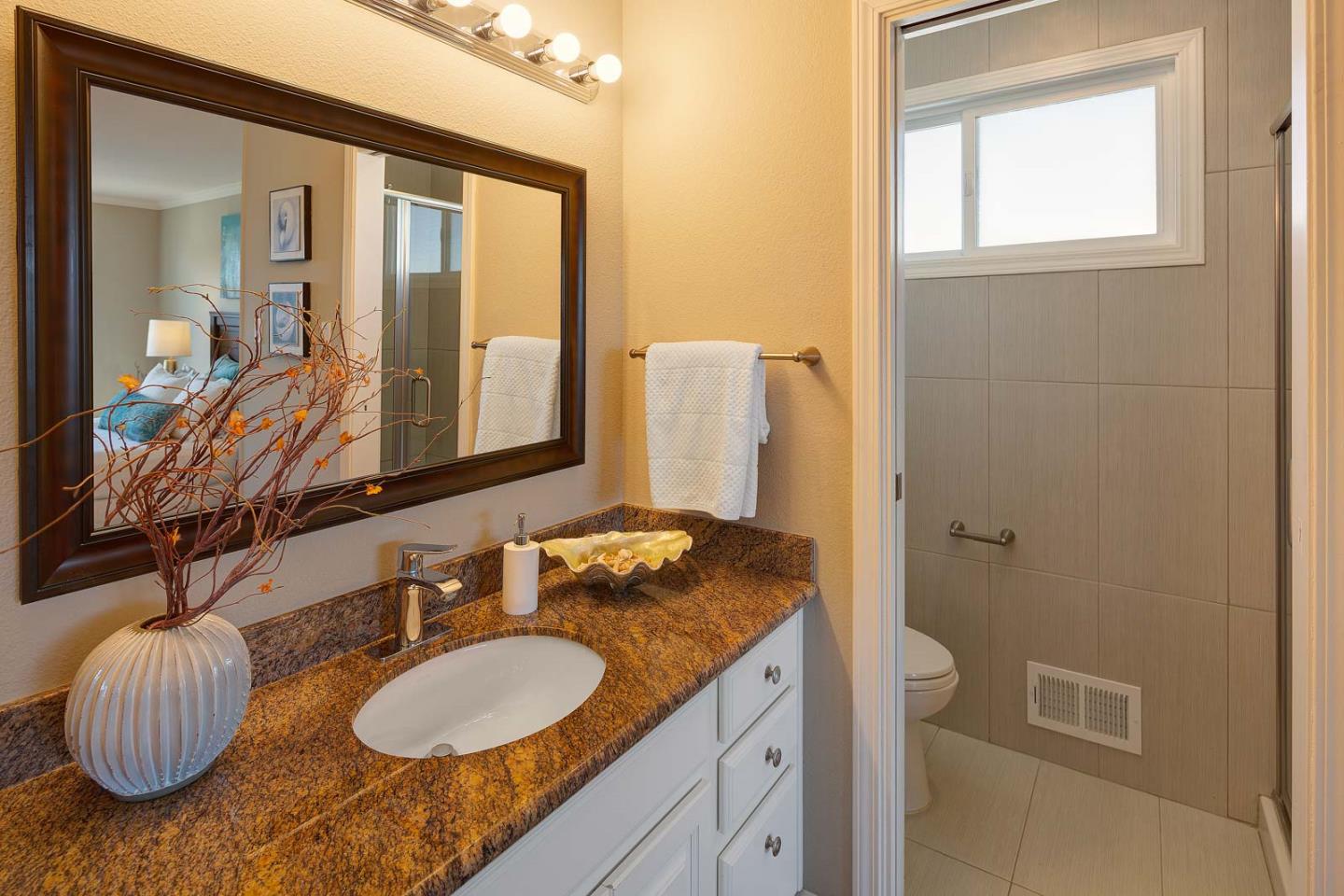 17 Moon Gate Court Pacifica, CA 94044 - Photo 26 of 36 a bathroom with a granite countertop sink and a mirror