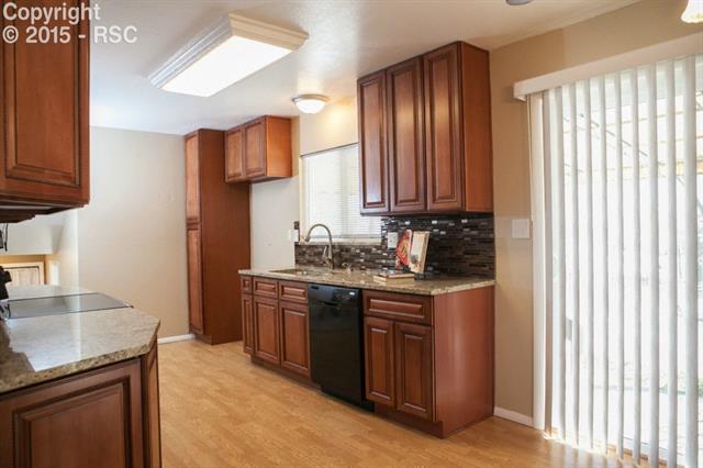 6965 Chippewa Road Colorado Springs, CO 80915 - Photo 4 of 31 Slab granite, glass tile backsplash, and all new 45' Maple Cabinets and pantry. Brand new water and light fixtures throughout!