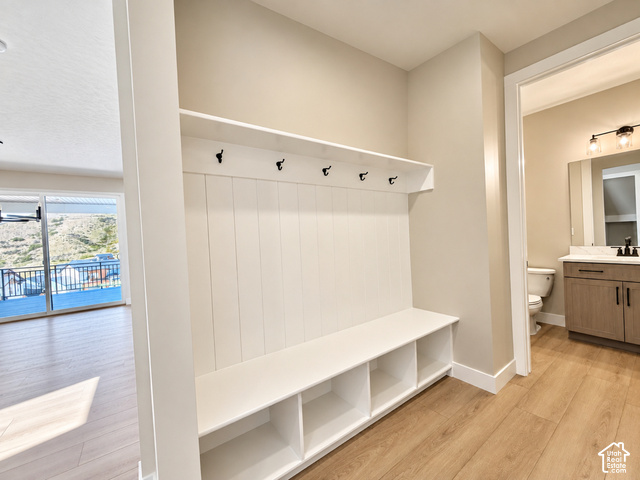 1595 West Canyon Rim Road, Unit 630 Lehi, UT 84048 - Photo 40 of 41 Built-in bench with storage cubbies and coat hooks, wood-finish flooring, and a sliding glass door leading to an outdoor deck