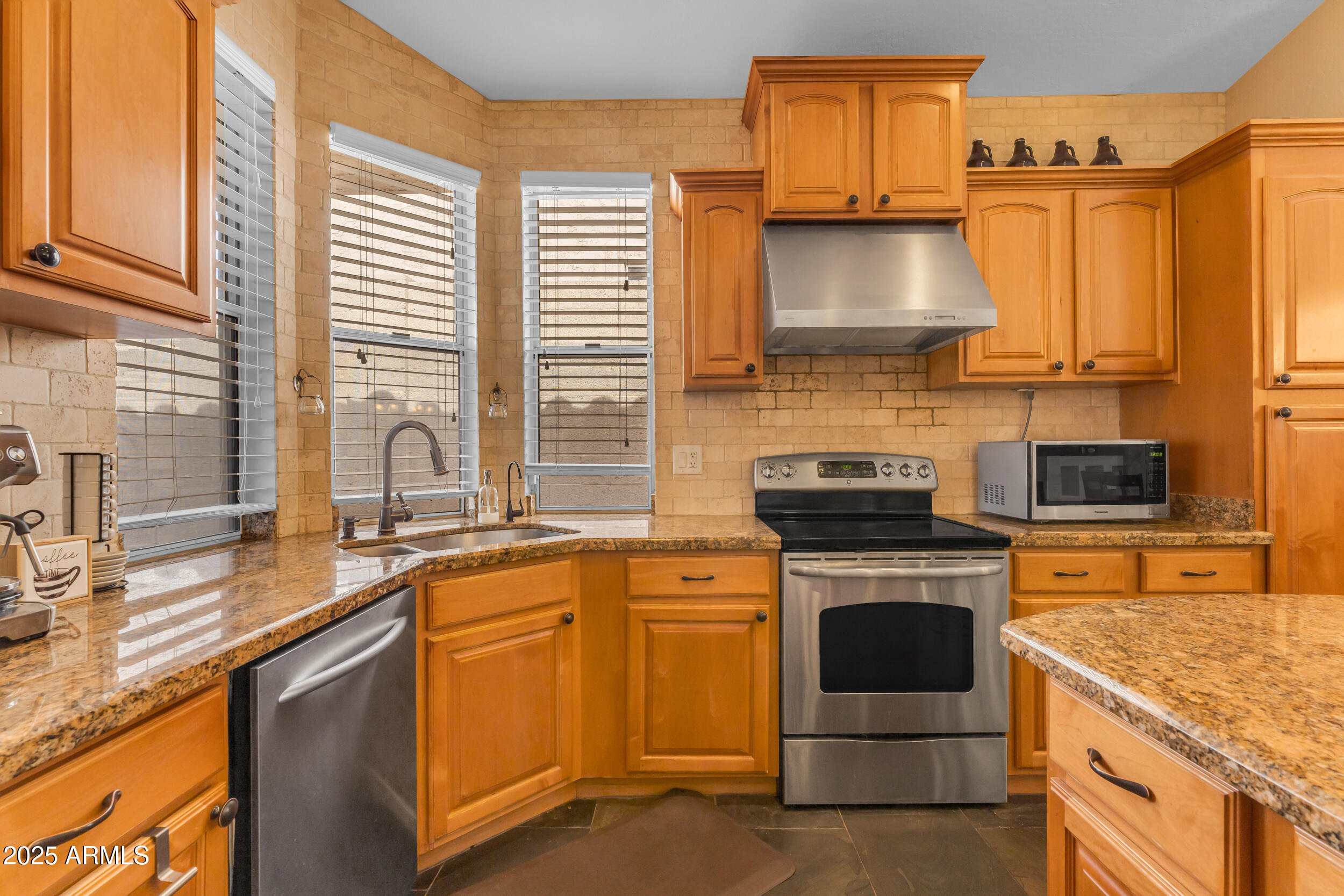 16044 South 24th Place Phoenix, AZ 85048 - Photo 14 of 42 a kitchen with granite countertop a sink stove and cabinets