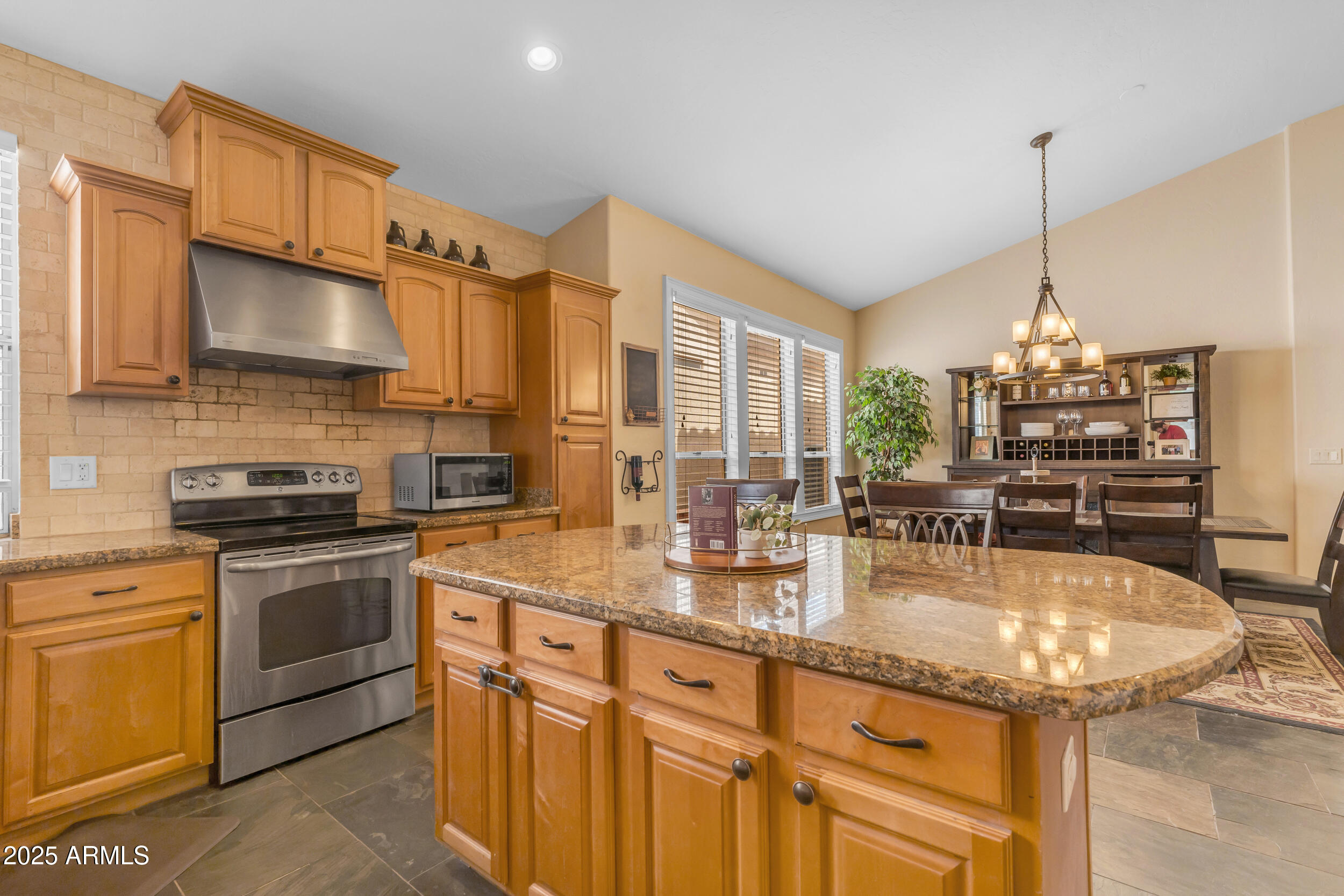 16044 South 24th Place Phoenix, AZ 85048 - Photo 15 of 42 a kitchen with stainless steel appliances granite countertop a sink a stove and a refrigerator