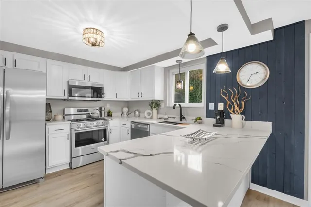 a kitchen with a refrigerator a stove cabinets and wooden floor