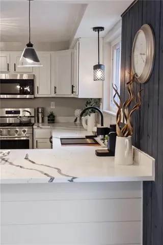 a kitchen with a sink a clock and cabinets