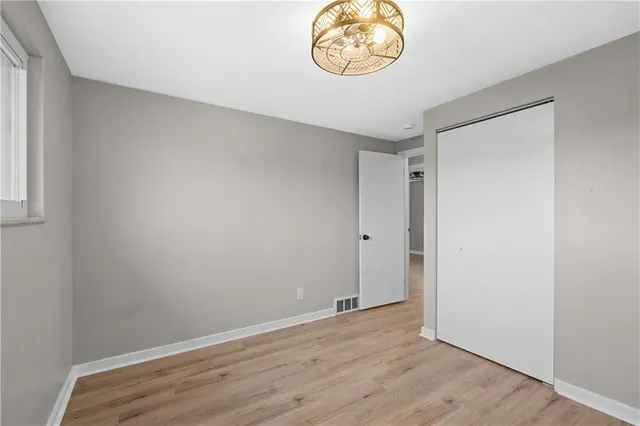 an empty room with wooden floor and window