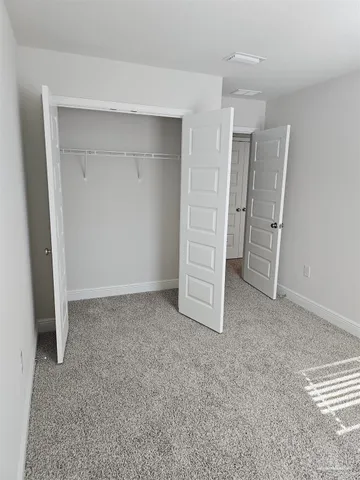 an empty room with closet and mirrors