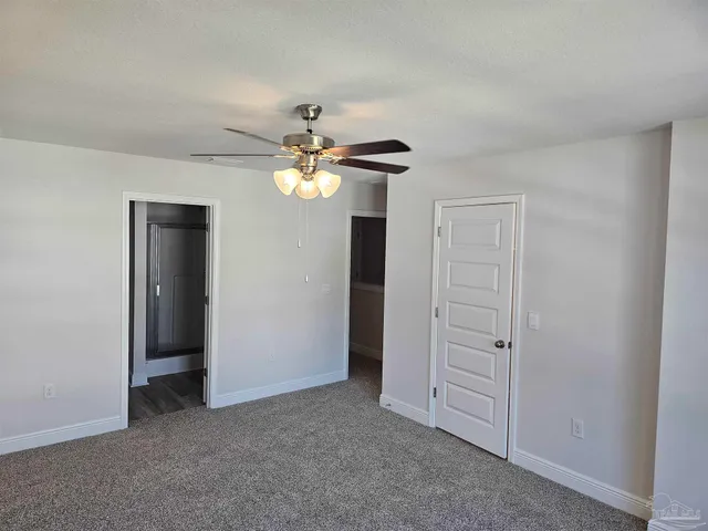an empty room with chandelier fan