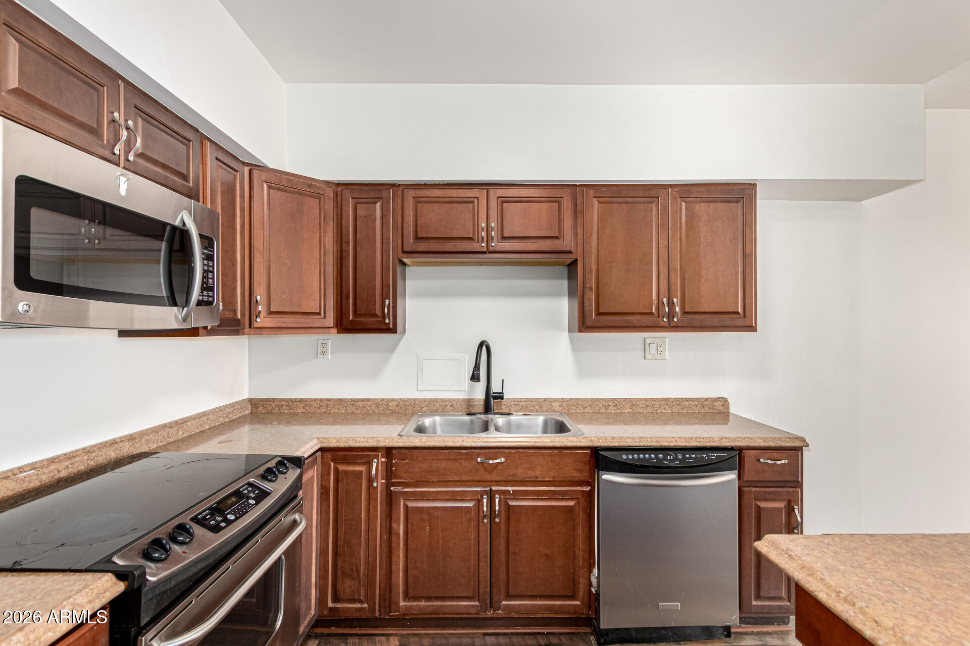357 East Thomas Road, Unit A111 Phoenix, AZ 85012 - Photo 17 of 41 a kitchen with stainless steel appliances a sink dishwasher stove and microwave with wooden cabinets