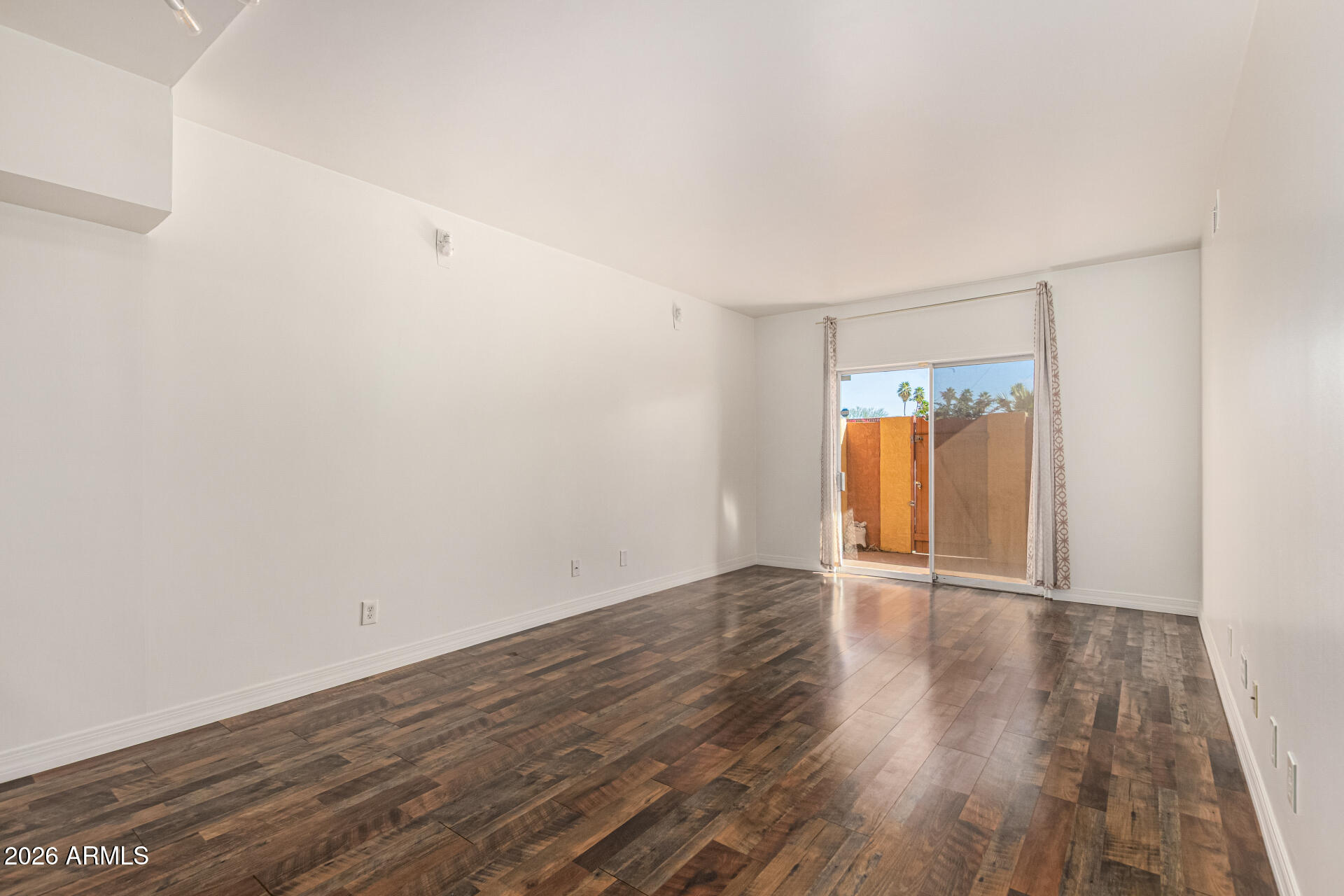357 East Thomas Road, Unit A111 Phoenix, AZ 85012 - Photo 4 of 41 a view of an empty room with wooden floor and a window