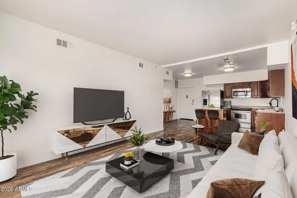 a living room with furniture kitchen view and a window