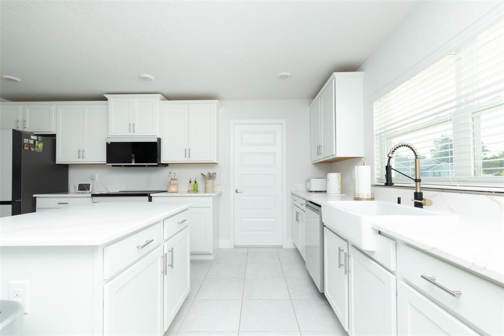 11267 Northwest 4th Street Ocala, FL 34482 - Photo 22 of 86 a kitchen with a sink a stove and a refrigerator