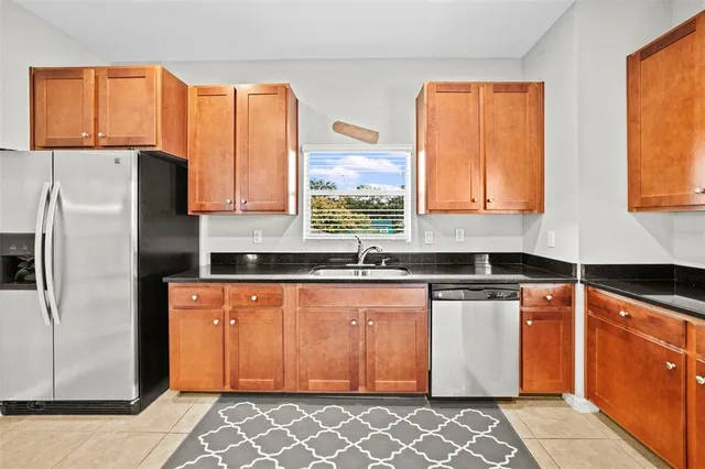 a kitchen with stainless steel appliances granite countertop a refrigerator and a sink