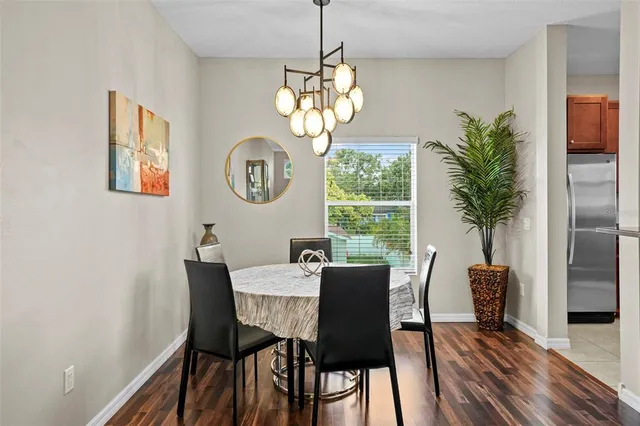 a dining room with furniture potted plants and wooden floor