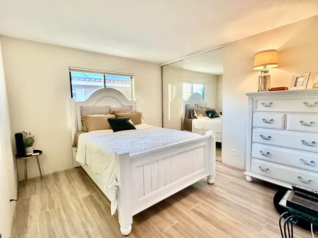 a bedroom with a bed and wooden floor