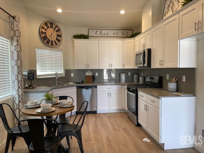 Undisclosed Address Bakersfield, CA 93314 - Photo 11 of 12 a kitchen with a stove a sink a microwave and cabinets