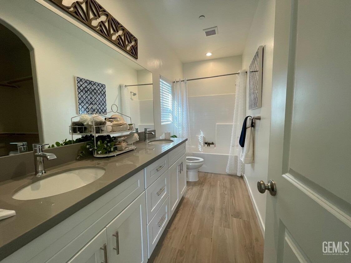 Undisclosed Address Bakersfield, CA 93314 - Photo 6 of 12 a bathroom with a sink a toilet a mirror and shower