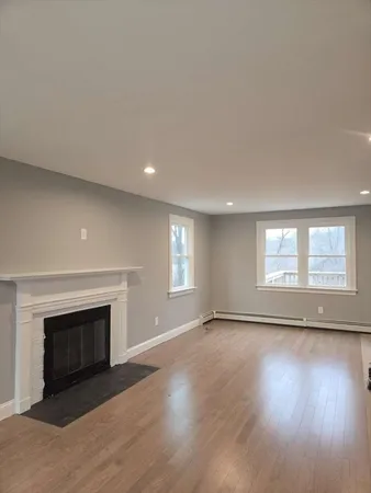 an empty room with wooden floor and fireplace