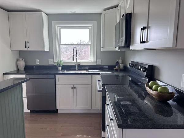 a kitchen with stainless steel appliances granite countertop a sink stove and cabinets