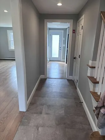 a view of a hallway with wooden floor and staircase