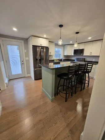 a kitchen with stainless steel appliances granite countertop a sink a stove and a refrigerator