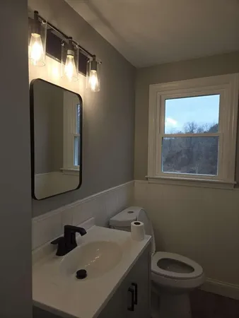 a bathroom with a toilet sink and mirror