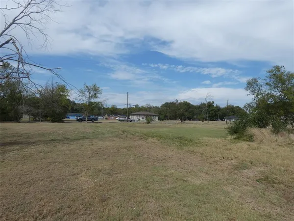 a view of dirt field and trees