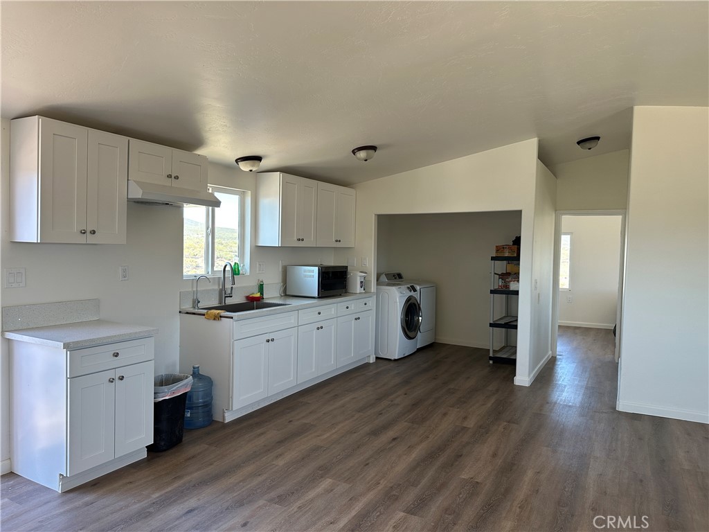 39035 Indian Road Anza, CA 92539 - Photo 2 of 8 a large kitchen with a wooden floor and white stainless steel appliances