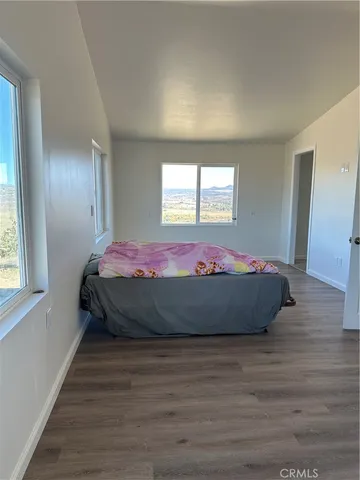 a bed room with a bed window and wooden floor